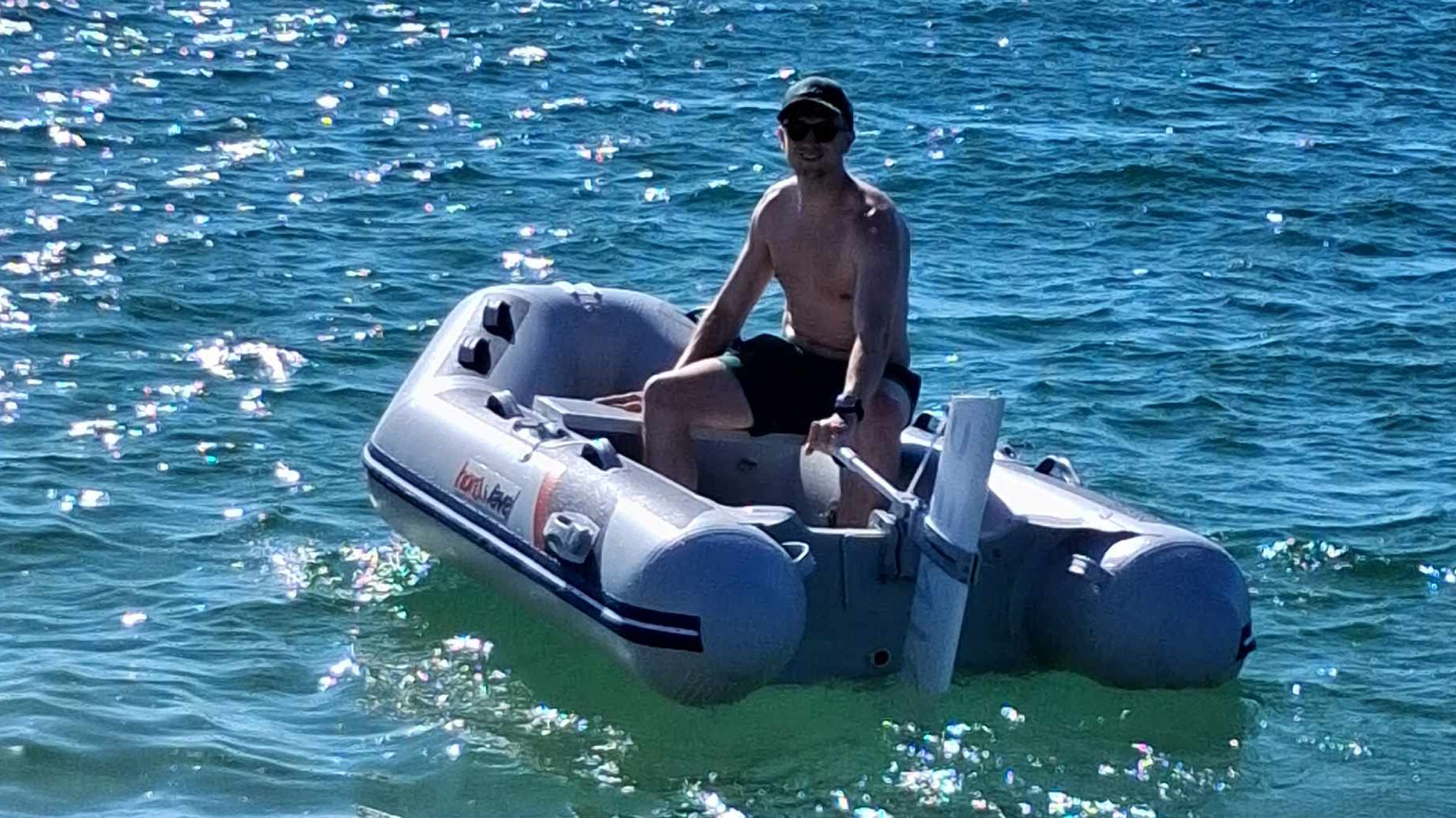 Person on the small inflatable boat with Remigo electric outboard fitted