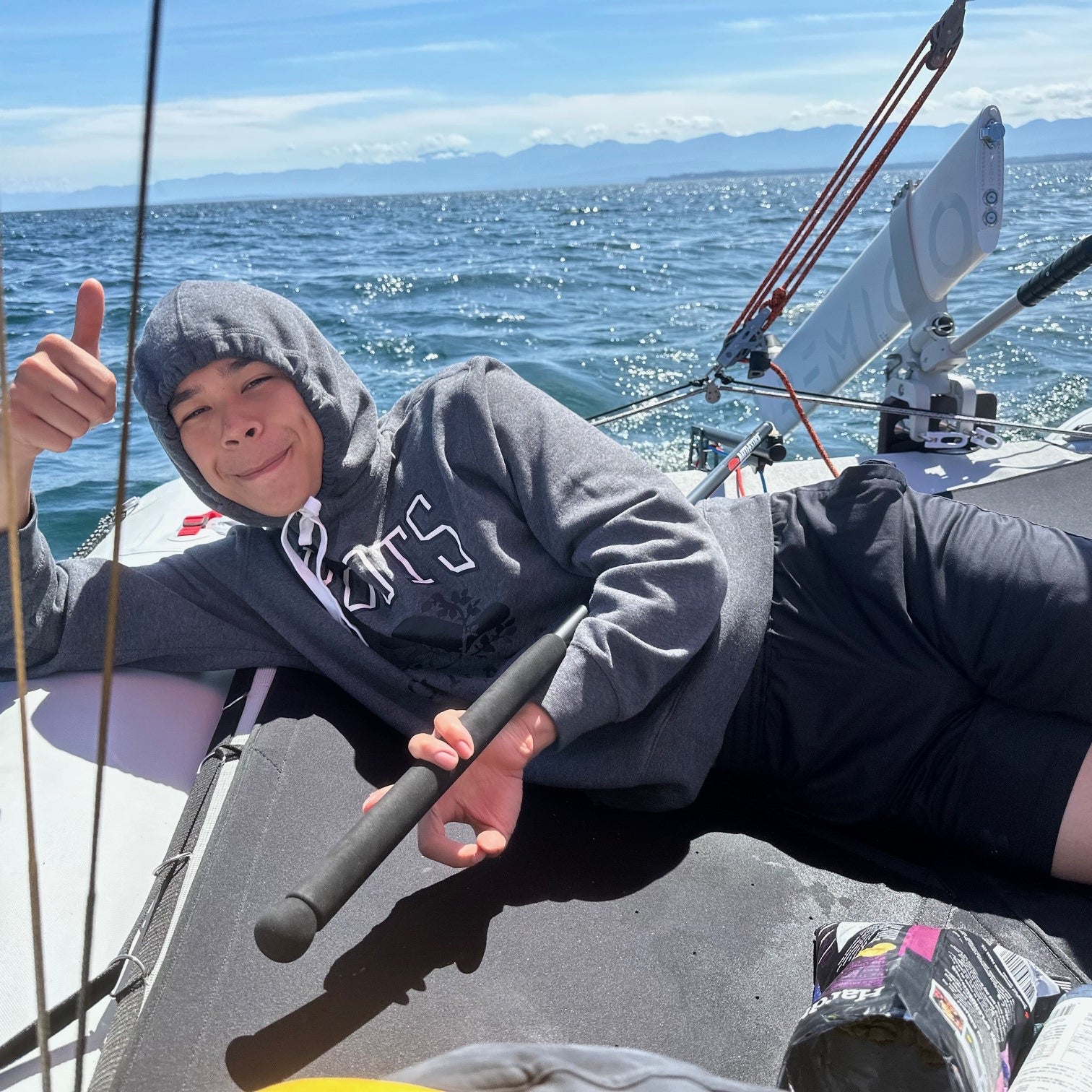 Person on a sailboat MiniCat 520 Explorer giving a thumbs-up with a scenic ocean background-customer photo