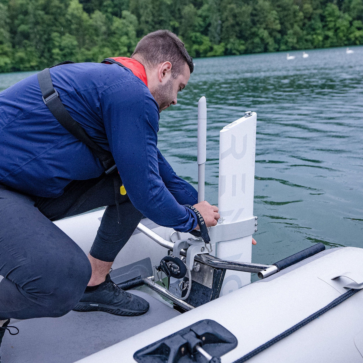 Person securing a Remigo electric outboard on the boat