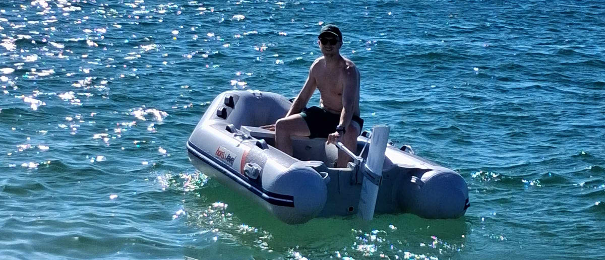 Person on the small inflatable boat with Remigo electric outboard fitted