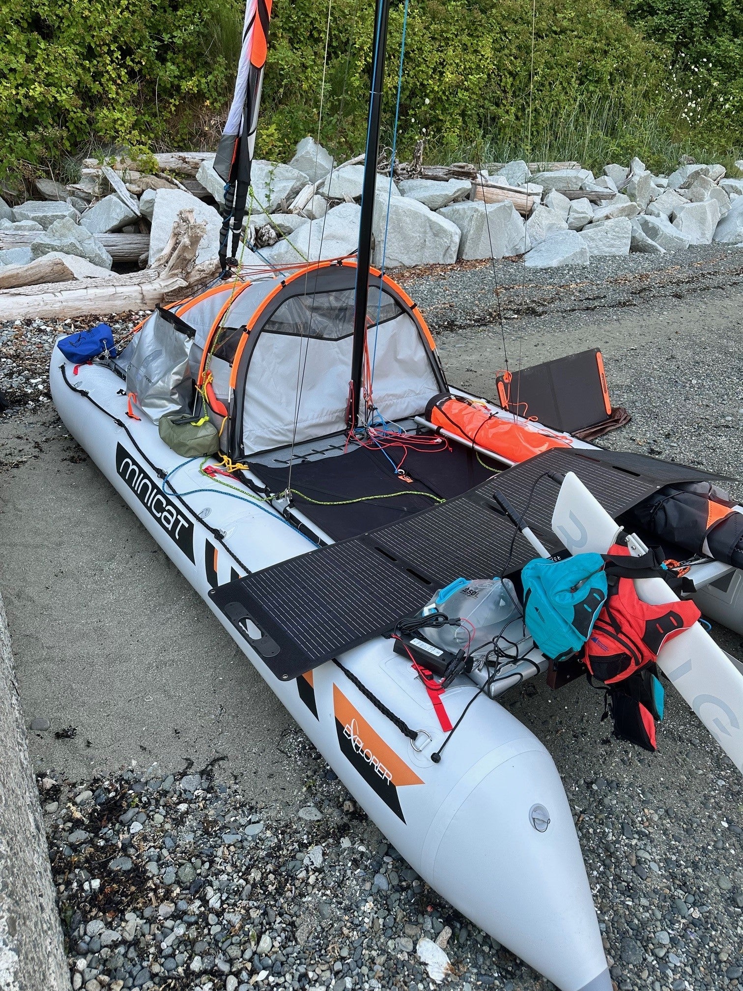 Inflatable catamaran 520 Explorer with solar panels and Remigo on a rocky shoreline - customer photo