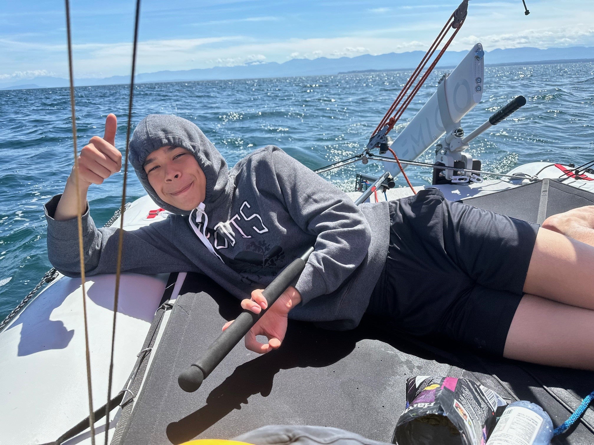 Person on a sailboat MiniCat 520 Explorer giving a thumbs-up with a scenic ocean background-customer photo