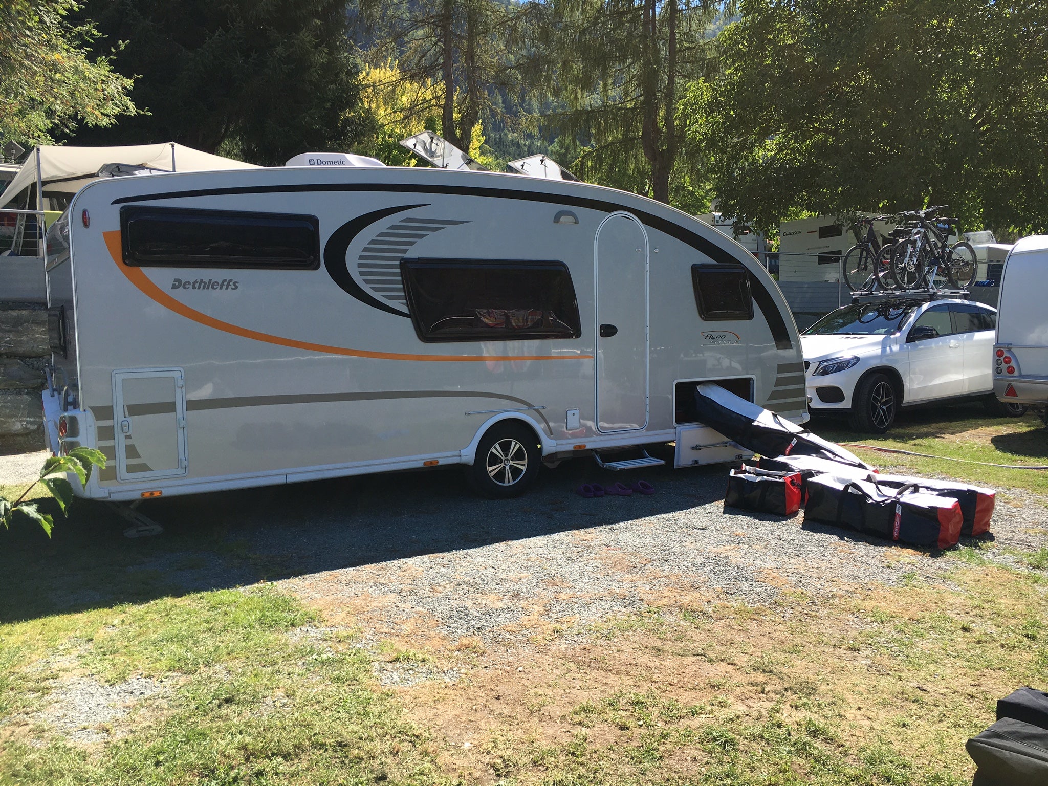 White caravan with bags containing inflatable boat MiniCat 